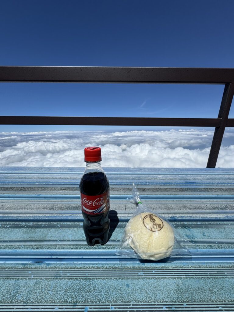 八合目トモエ館の限定あんぱんとコーラ、背景に雲海