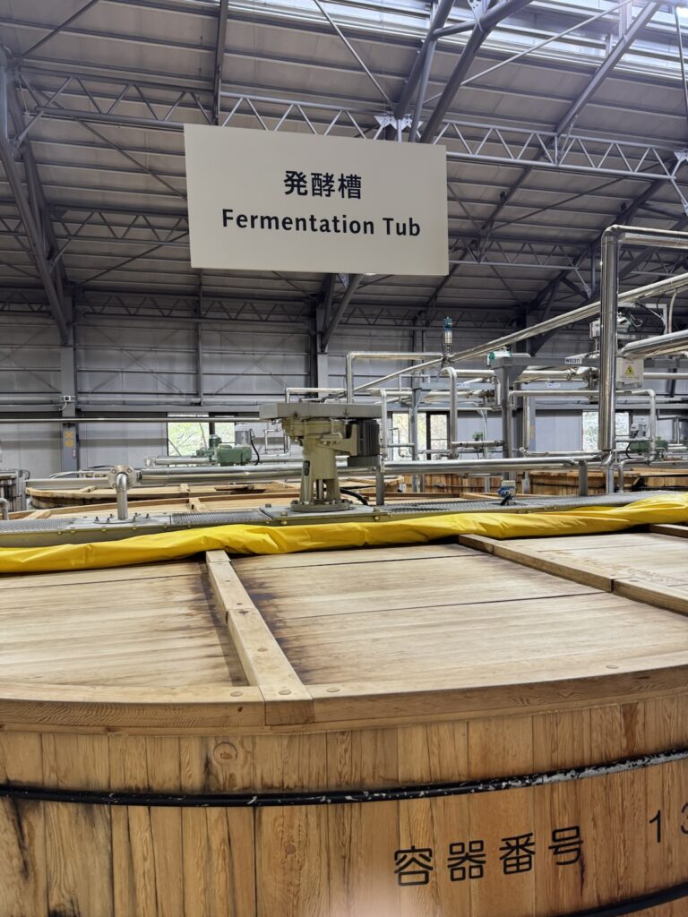 白州蒸溜所の木桶の発酵槽と「発酵槽 Fermentation Tub」の看板