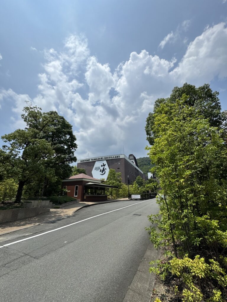 夏の青空と雲の下に見える山崎蒸溜所の建物と坂道